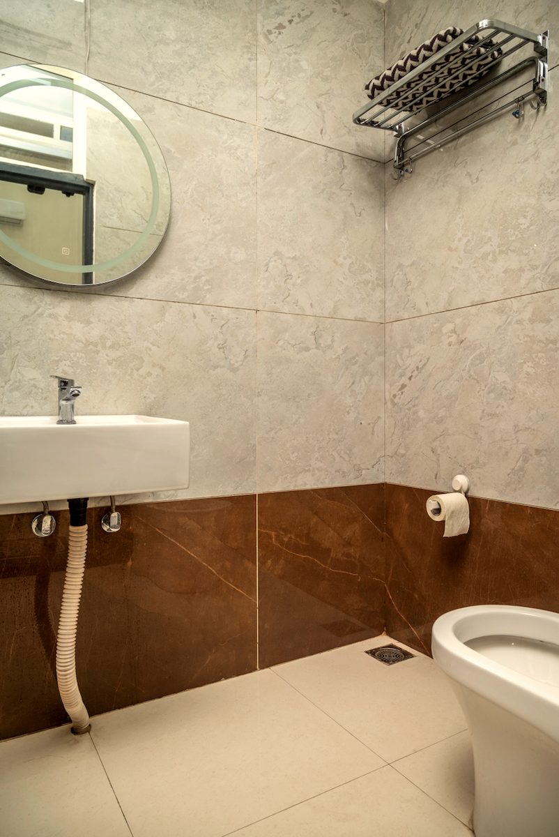 En-suite bathroom with round mirror and sink