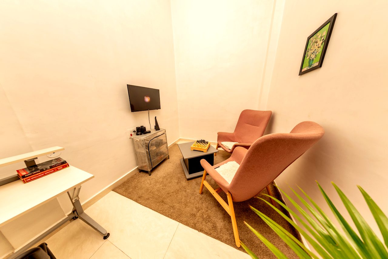 Blush armchair and work desk with a wall-mounted TV in the Premium room